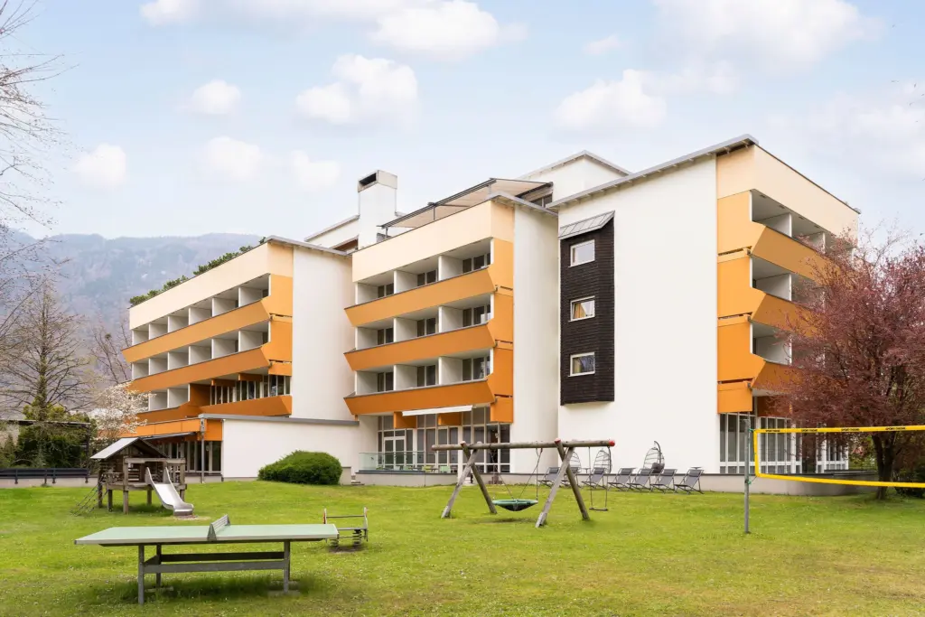 Außenbereich mit Grünfläche und modernem Gebäude im Hintergrund