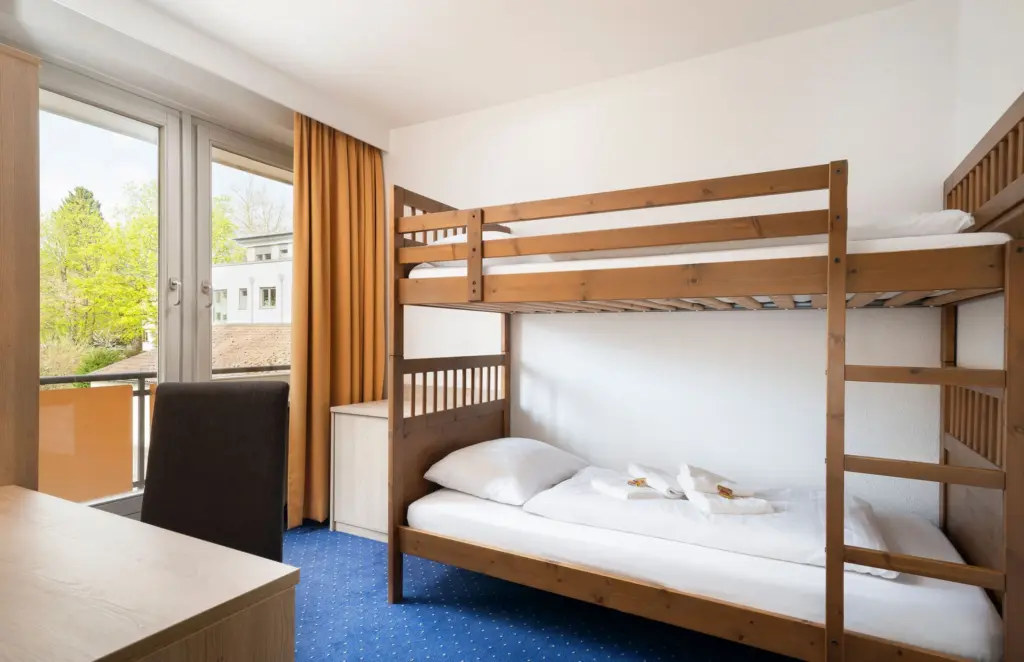 Hotelzimmer mit Stockbett und großem Fenster