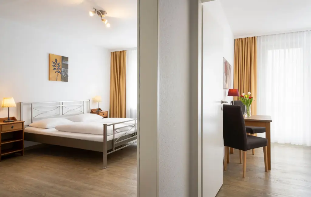 Hotelzimmer mit Doppelbett und Tisch